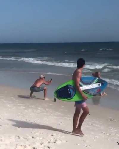 2 guys at the beach decided to imitate 2 other girls who were taking sexy photos to post on their social network