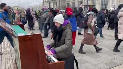 Outside Lviv station, which is thronging with exhausted refugees fleeing war in eastern Ukraine, an accomplished pianist is playing “What a Wonderful World.” It’s hauntingly beautiful.