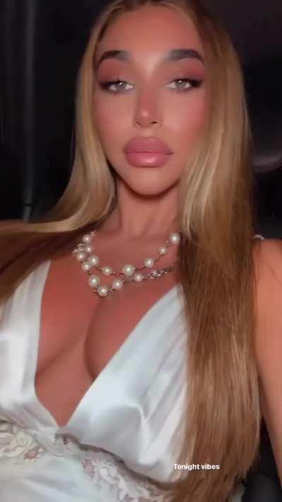 wearing a white lace dress and pearl necklace in car