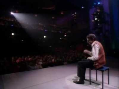 Rowan Atkinson rocks on, playing an invisible drum set in a 1992 television special.