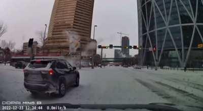 Calgary Transit bus snow drifting into traffic light