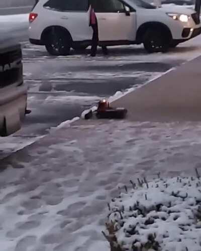 A toy plow truck clearing snow at a mall.