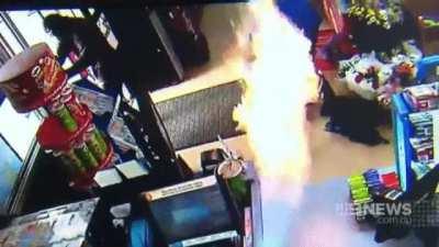 Store clerk using flame thrower to fight off robbers.