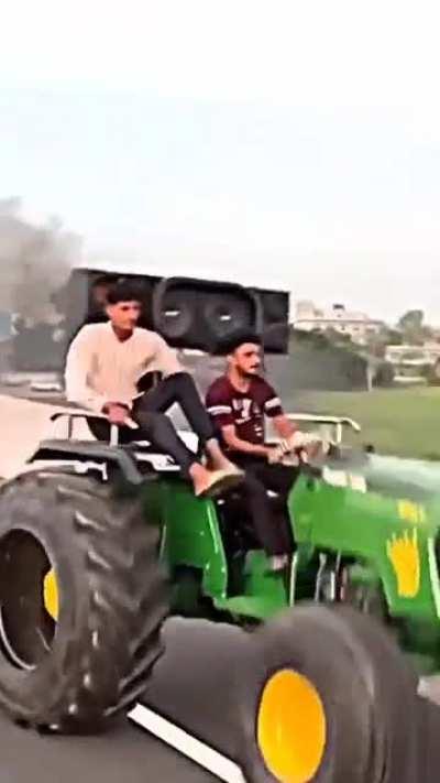 Sitting on a tractor doing wheelies.