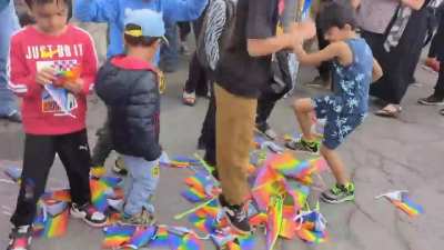 Religious parents teaching their kids to hate LGBTQ+ people by stomping on pride flags during pride flags in Canada