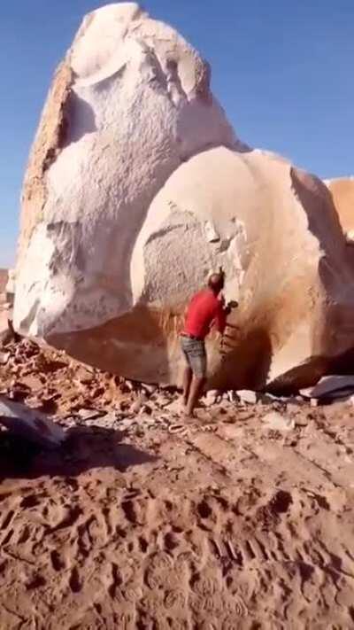Человек ломает скалу
