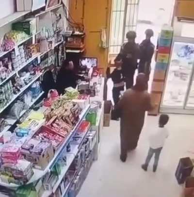Israeli soldiers assault a Palestinian child in a shop in Hebron (Occupied West Bank)
