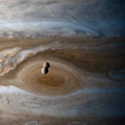 The moons Io and Europa passing by Jupiter, caught by Cassini