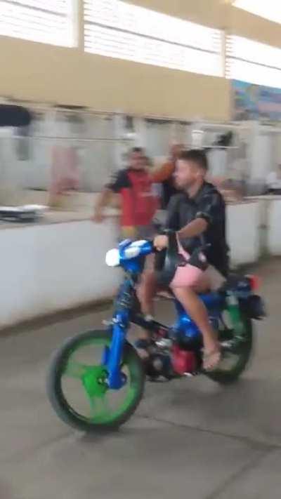 Man with motorized bike at market takes a tumble