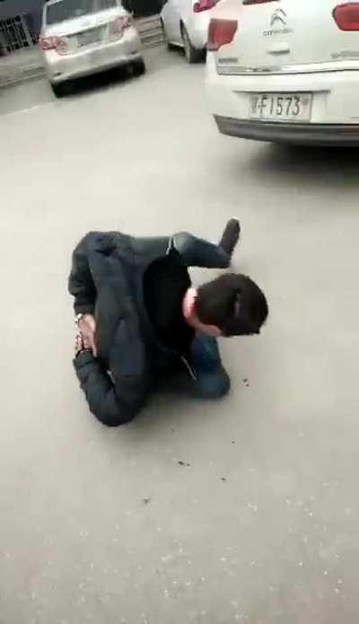 Police in China beating up a man until he spits out blood