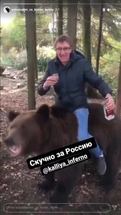 Russian man drinking vodka while riding a bear