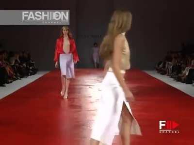 Model tries (unsuccessfully) to contain her breasts