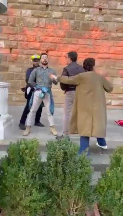 Florence mayor blocks an 'activist' as he daubs city hall building with paint.