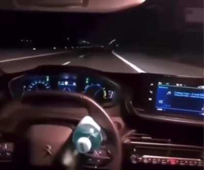 …riding in the back seat of a Peugeot using a bottle of water