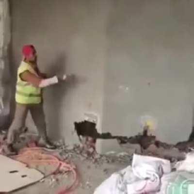 Walking under the wall the worker is breaking down