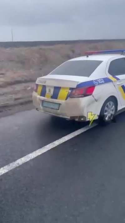 Сотрудники Национальной полиции Украины сопровождают группу элитных автомобилей в направлении границы с одной из европейских стран. Простых людей отгоняют автоматами.