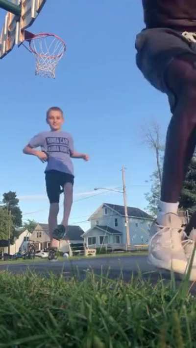 Guy teaches kid how to shoot a basketball