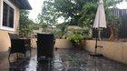Sudden tropical rain washing down cozy patio.