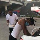 Two young men in Miami, Overtown, feed the homeless from their car