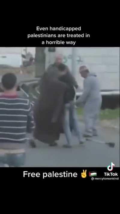 Terrorist israeli forces attacks a Palestinian on a wheelchair.