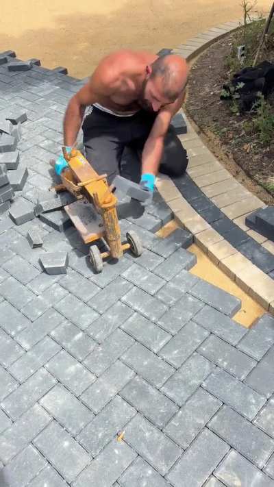 Man cuts and places blocks precisely around a circle