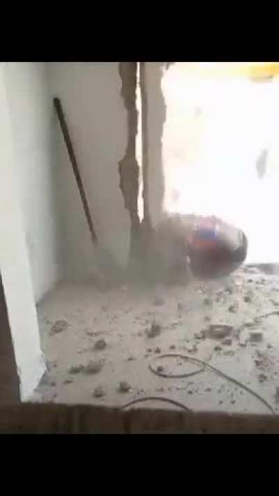 A construction worker was peacefully drilling a wall when suddenly part of the wall fell on him