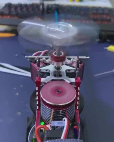 Stripped down RC Helicopter shows the working of the swashplates. The silver piece attached to the silver/black servo links (one on backside). This swashplate does not rotate with the main rotor. The red swashplate rotates with the main rotor. (repost sin