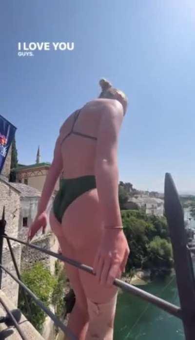 Woman performs a very high dive off a bridge