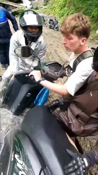 A group of bikers in Nepal find a foreign rider who was wiped out and clinging to his bike only inches from a cliff edge. They get him back up and riding again.
