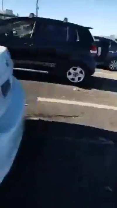 Woman records people stealing cigarattes packages dropped by recently crashed car while the man is struggling for his life.