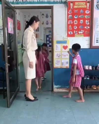 Teacher plays. A game with her students before entering her classroom