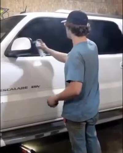 he is spray painting the window black. 0% tint...