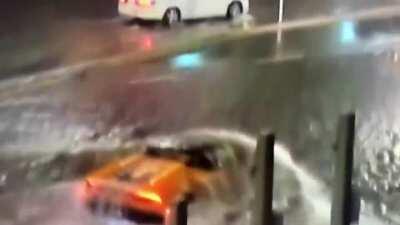 Lambo casually driving around stalled cars on flooded road during Tropical Storm Eta in Miami