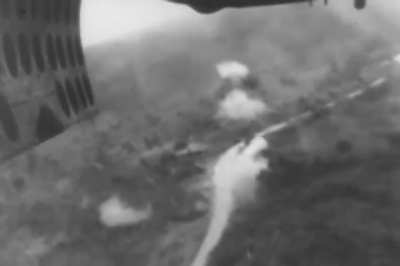 Bomb bay camera on a B-25 Mitchell catches a fellow aircraft with guns blazing during a raid on Tarakan Island in April 1945