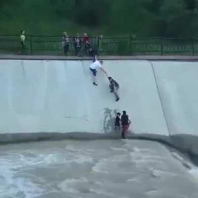 Drowning dog is saved by a group of madlads forming a human chain.