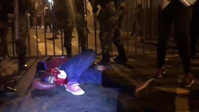 La policía evitando que se le de primeros auxilios a una joven a la cual le provocaron convulsiones