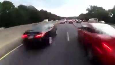 Bikes pass between cars in traffic