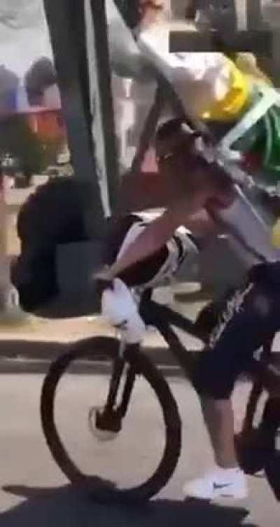 An idiot on a bicycle,( with a giant statue of Jesus on his back) , not looking ahead