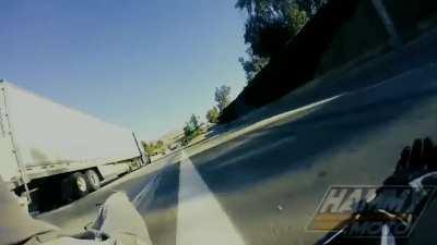 rider crashes under a semi truck