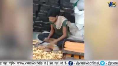 Abdul Nazim, a bakery worker licks bread before slicing it. Location - Amravati, Maharashtra