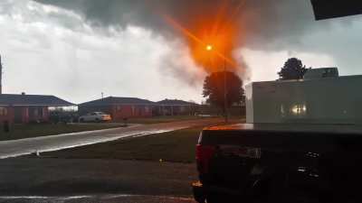 Camera man holds their ground while filming the formation and path of a tornado