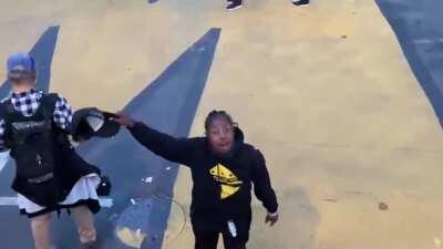 A woman expresses her disgust towards the police as they stand by and let Trump supporters destroy a BLM Mural