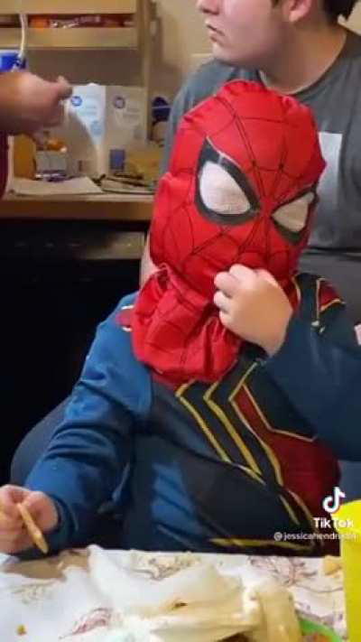 Kid eating crackers wearing a mask.