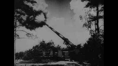 Glider, Then Artillery fired from a huge gun on train tracks. Hitler being cheered ion, German band plays.