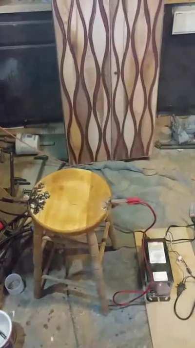 Using electrodes to burn a pattern on an old stool