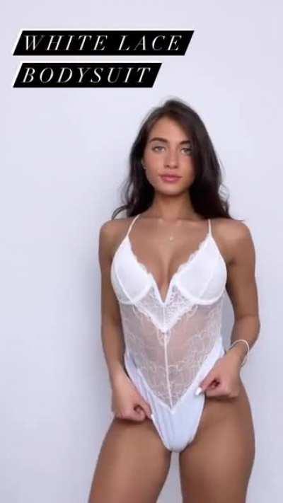 White lacy lingerie one piece up against the wall