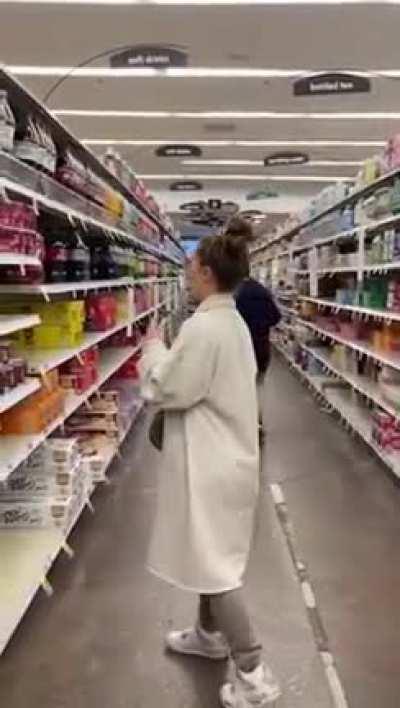 Woman repeatedly opens food and spits in it, reseals it and puts it back on shelf in supermarket