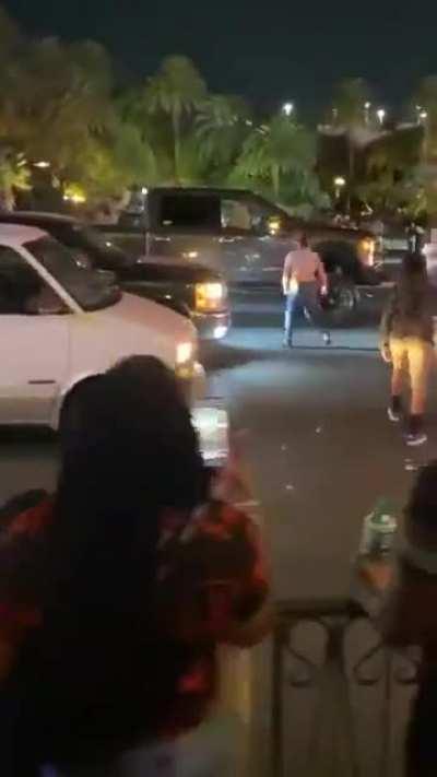 Anti-Trump protestor bangs on windows, doors of a pickup with Trump flag flying. Truck's driver runs out and shoves protestor