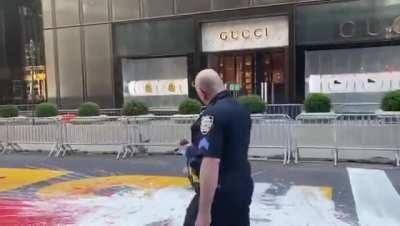Grown man on the ground covered in paint trying to deface a BLM mural