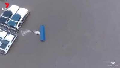 Boat owner saves houseboats from cargo crate during massive flooding in Australia
